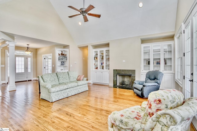 living room with high vaulted ceiling, light hardwood / wood-style flooring, decorative columns, and ceiling fan