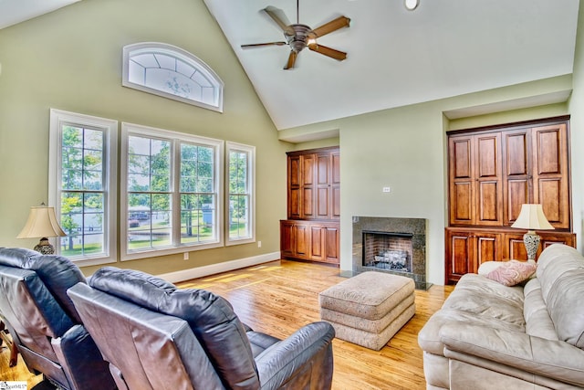 living room with high vaulted ceiling, ceiling fan, and light hardwood / wood-style floors