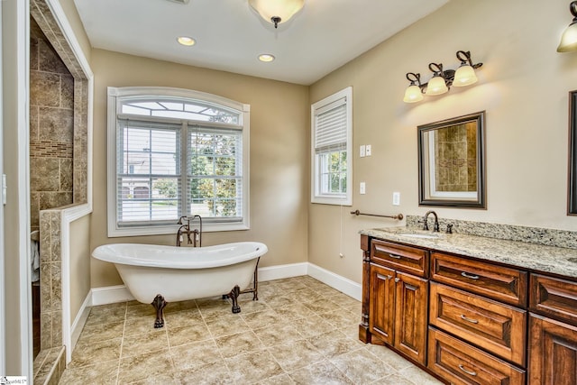 bathroom with tile patterned floors, vanity, and a tub to relax in