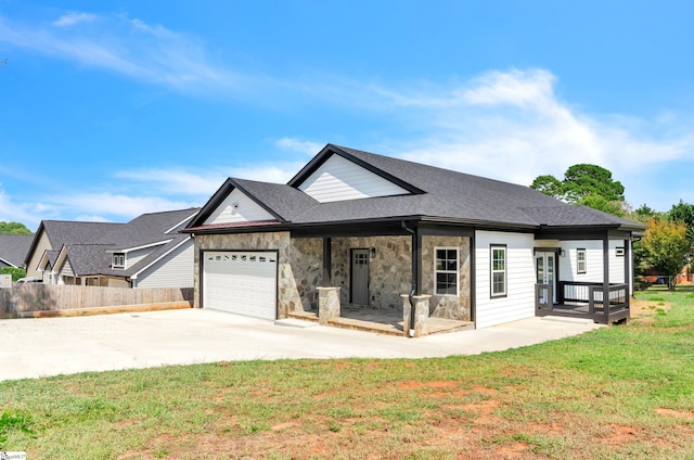 view of front of home featuring concrete driveway, fence, an attached garage, stone siding, and a front lawn