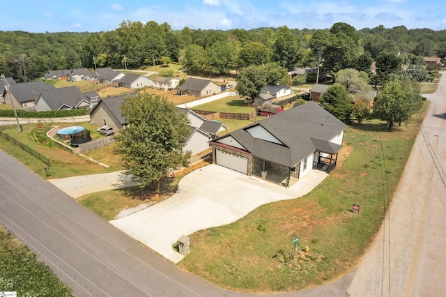 drone / aerial view featuring a forest view and a residential view