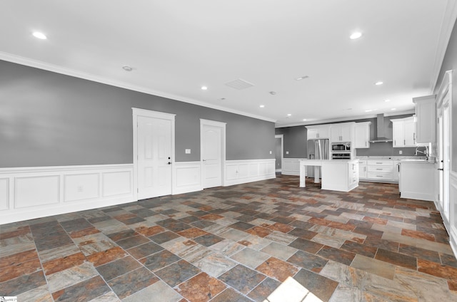 kitchen with open floor plan, light countertops, wall chimney exhaust hood, and appliances with stainless steel finishes