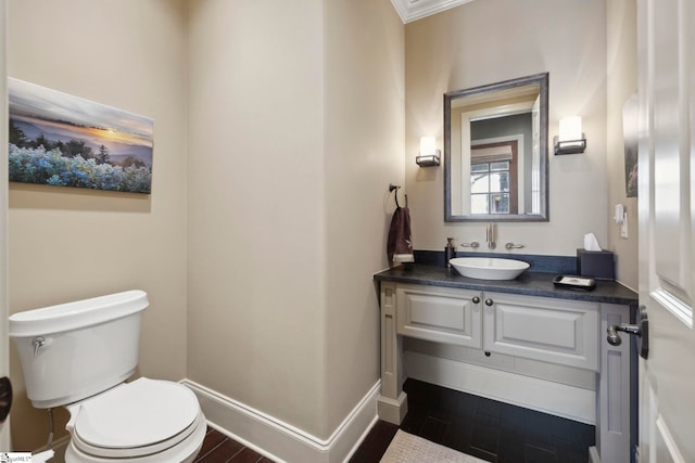 bathroom featuring toilet, ornamental molding, vanity, and wood-type flooring