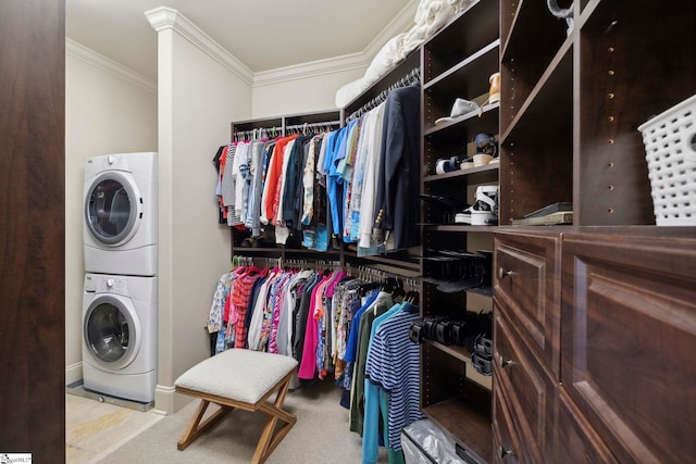 spacious closet with light colored carpet and stacked washing maching and dryer