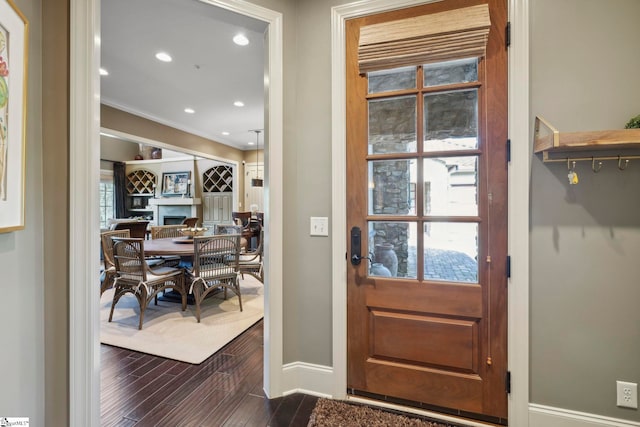 foyer with wood-type flooring and ornamental molding