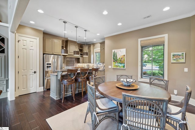 dining area with ornamental molding and dark hardwood / wood-style floors