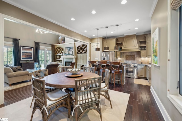 dining space featuring ornamental molding, dark hardwood / wood-style floors, and track lighting