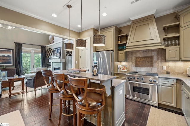 kitchen featuring stainless steel appliances, hanging light fixtures, backsplash, an island with sink, and premium range hood