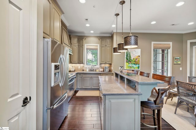 kitchen featuring stainless steel appliances, hanging light fixtures, a center island, decorative backsplash, and dark wood-type flooring