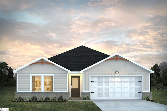 view of front of property with a yard and a garage