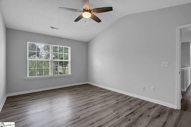 empty room with ceiling fan, a textured ceiling, hardwood / wood-style floors, and vaulted ceiling