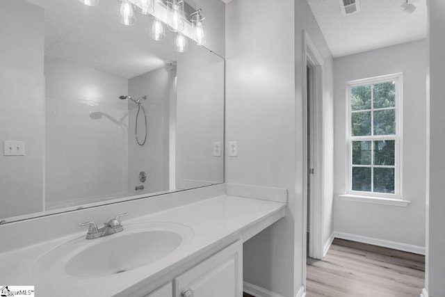 bathroom featuring vanity, a textured ceiling, shower / tub combination, and hardwood / wood-style flooring