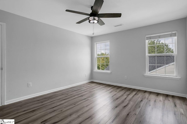 spare room with ceiling fan, hardwood / wood-style flooring, and a wealth of natural light