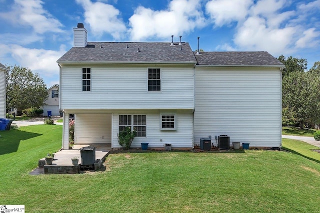 rear view of house with central air condition unit and a yard