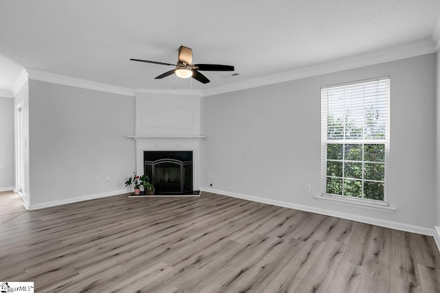 unfurnished living room with light wood-type flooring, crown molding, ceiling fan, and a healthy amount of sunlight