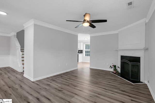 unfurnished living room with ceiling fan, crown molding, and wood-type flooring