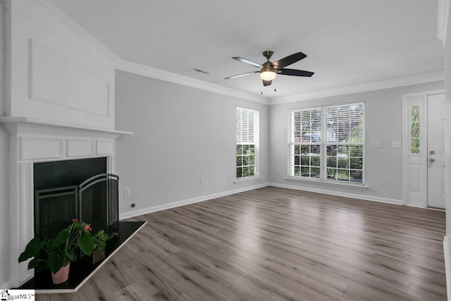 unfurnished living room with hardwood / wood-style floors, ornamental molding, a textured ceiling, and ceiling fan