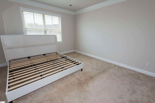 unfurnished bedroom with light carpet and crown molding