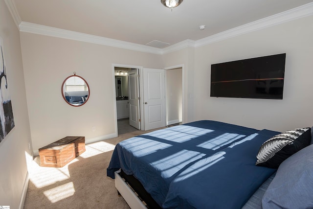 carpeted bedroom with ornamental molding and ensuite bath