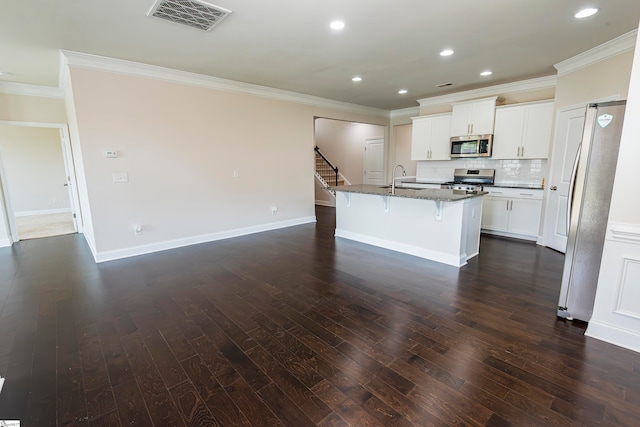 kitchen with an island with sink, white cabinetry, dark wood-type flooring, and appliances with stainless steel finishes