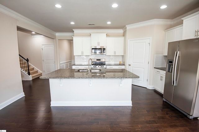 kitchen with stainless steel appliances, dark wood-type flooring, sink, and an island with sink