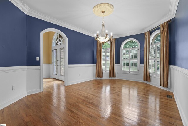 unfurnished room featuring a chandelier, light hardwood / wood-style flooring, and ornamental molding