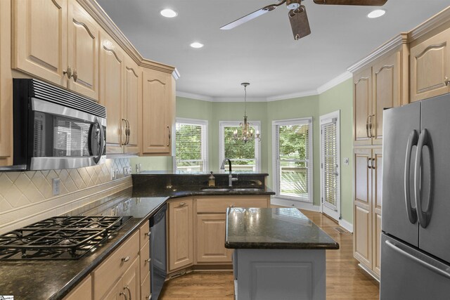 kitchen featuring a center island, crown molding, sink, and appliances with stainless steel finishes