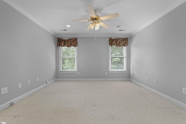 empty room featuring ceiling fan, a healthy amount of sunlight, ornamental molding, and light carpet