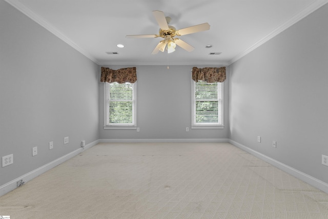 carpeted empty room featuring a ceiling fan, visible vents, baseboards, and crown molding