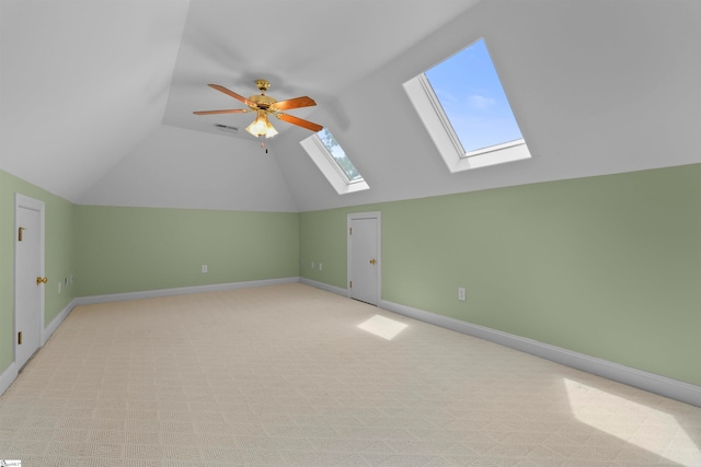 bonus room with ceiling fan, light colored carpet, and lofted ceiling with skylight