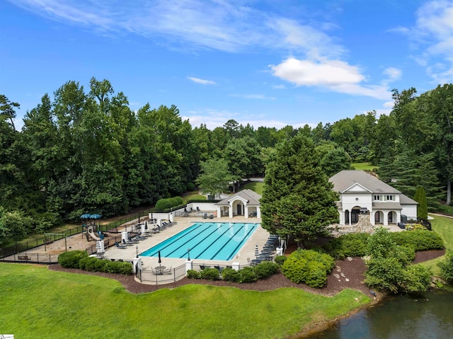 view of swimming pool with a yard, a water view, and a patio