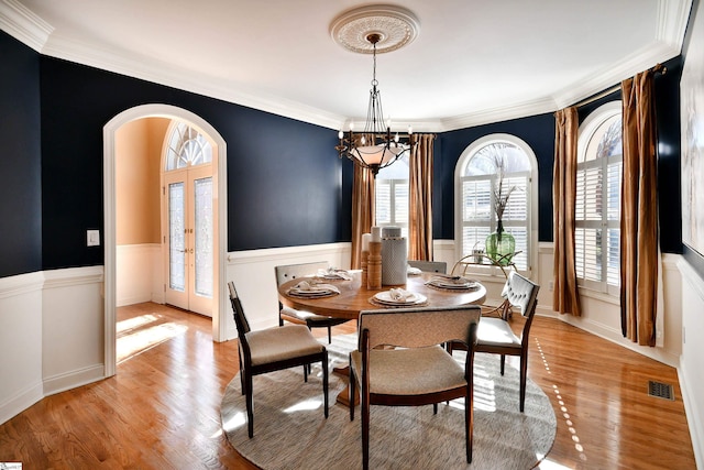 dining room featuring french doors, a healthy amount of sunlight, and light wood-type flooring