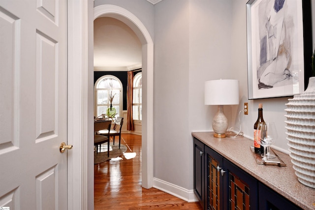 hallway featuring ornamental molding and light hardwood / wood-style flooring