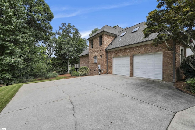 view of front of home with concrete driveway, brick siding, roof with shingles, and an attached garage