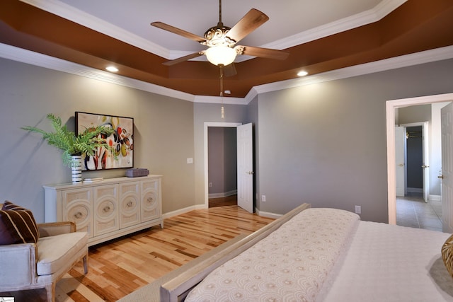 bedroom with hardwood / wood-style flooring, a raised ceiling, ceiling fan, and ornamental molding