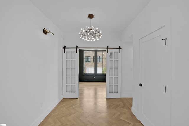 unfurnished dining area featuring french doors, a barn door, and light parquet floors