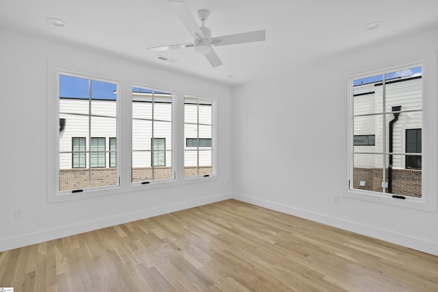 empty room with ceiling fan and light hardwood / wood-style floors