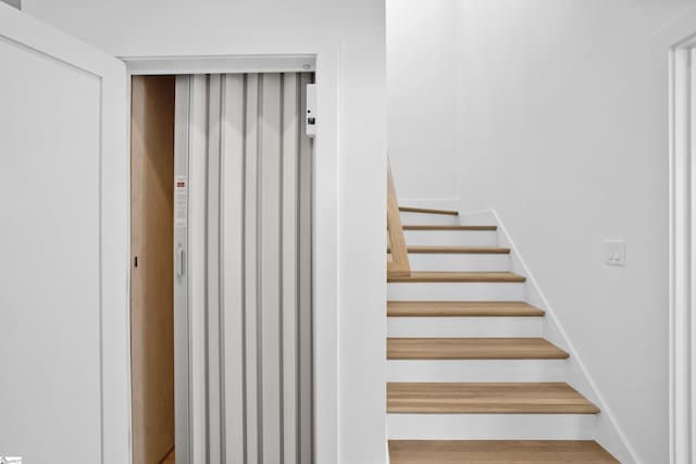 stairway featuring hardwood / wood-style floors and elevator