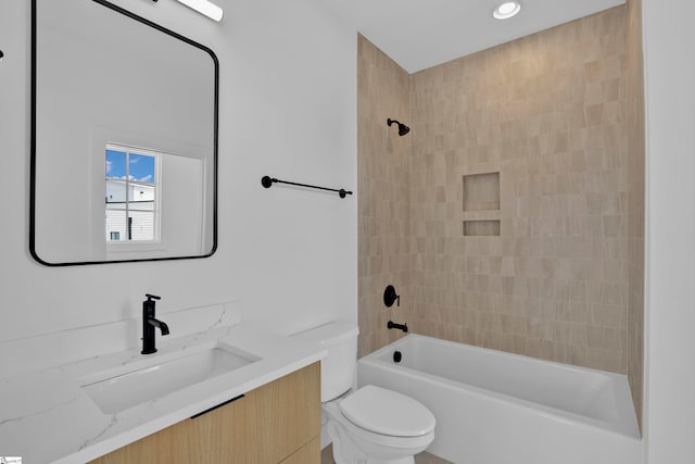 full bathroom featuring toilet, vanity, and tiled shower / bath