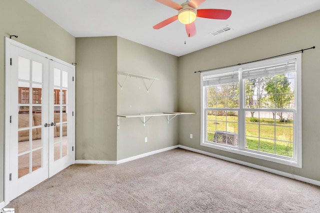 carpeted empty room with ceiling fan and french doors