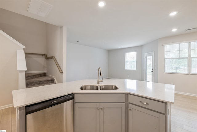 kitchen with sink, dishwasher, light hardwood / wood-style floors, and a healthy amount of sunlight