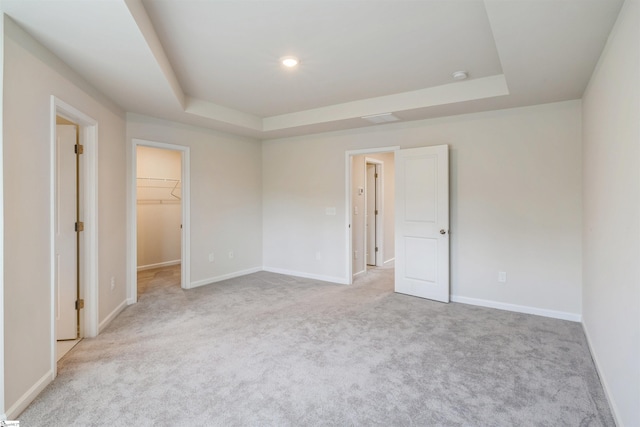 empty room with a tray ceiling and light carpet