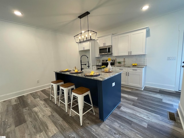 kitchen with a kitchen island with sink, dark hardwood / wood-style floors, electric range, and white cabinetry