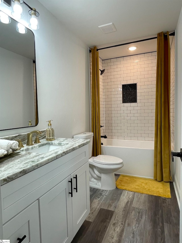 full bathroom featuring toilet, wood-type flooring, shower / tub combo, and vanity