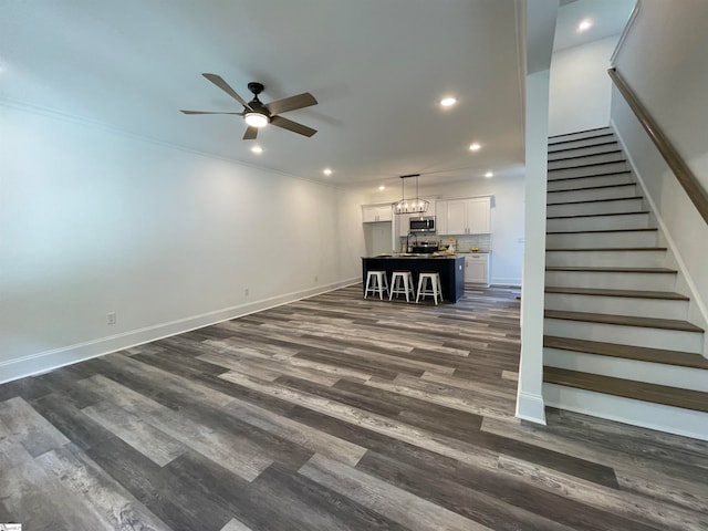 unfurnished living room featuring ceiling fan and wood-type flooring