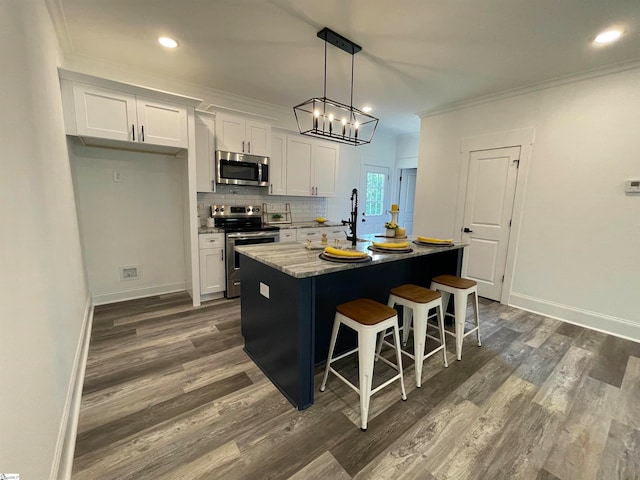 kitchen featuring dark hardwood / wood-style flooring, white cabinetry, a kitchen island with sink, and stainless steel appliances