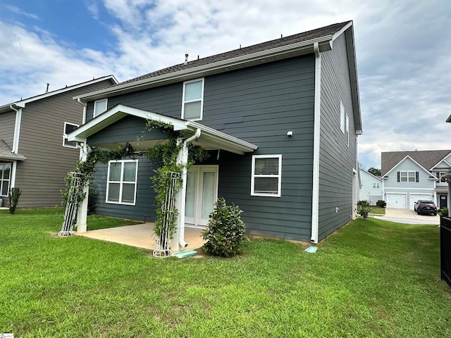 rear view of house with a garage and a yard