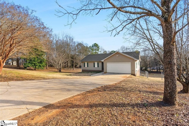 ranch-style house featuring driveway, a garage, fence, and a front lawn