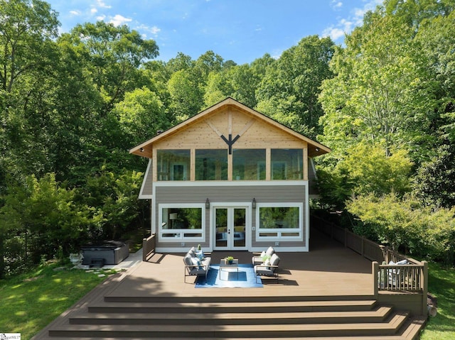 rear view of house with a wooden deck and a hot tub