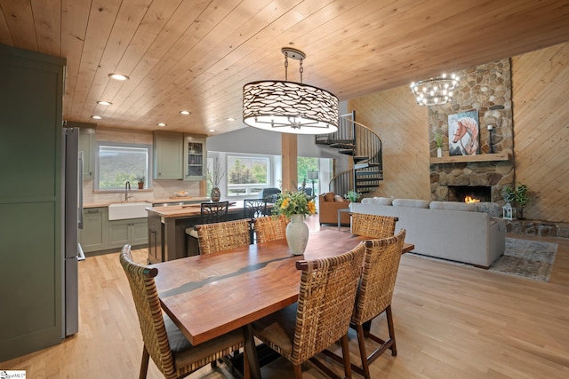 dining space with wooden walls, wooden ceiling, and light hardwood / wood-style floors